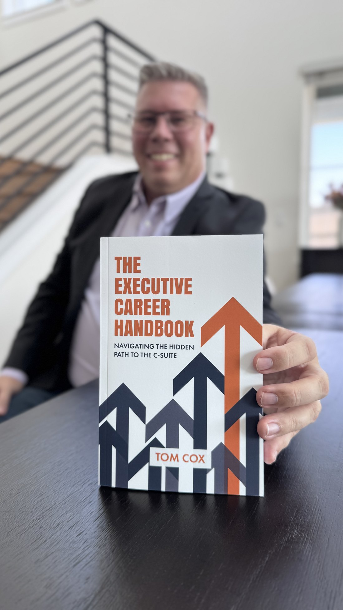 Tom Cox holding The Executive Career Handbook